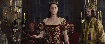 Movie still from “Snow White and the Huntsman” (2012), directed by Rupert Sanders – A beautiful young lady wearing a red and gold dress; Medium shot, Low angle