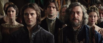 Movie still from “Snow White and the Huntsman” (2012), directed by Rupert Sanders – A group of men standing next to each other in a room; Close Up shot, Over the shoulder angle
