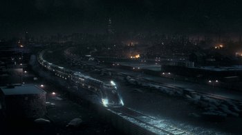 Movie still from “Snowpiercer” (2020), created by Graeme Manson – A train traveling down train tracks at night time; Extreme Wide shot, High angle