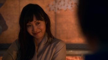 Movie still from “Snowpiercer” (2020), created by Graeme Manson – A woman smiling for the camera in front of a fire place; Close Up shot, Over the shoulder angle