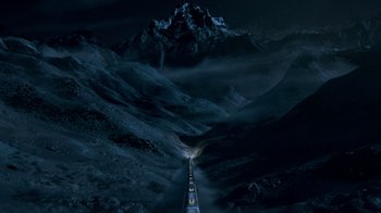 Movie still from “Snowpiercer” (2020), created by Graeme Manson – A train traveling through a valley at night; Extreme Wide shot, High angle