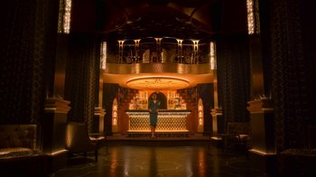 Movie still from “Snowpiercer” (2020), created by Graeme Manson – A woman standing in front of a bar in a room; Extreme Wide shot, Low angle