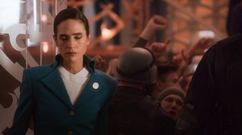 Movie still from “Snowpiercer” (2020), created by Graeme Manson – A woman standing in front of a group of people; Medium shot, Over the shoulder angle