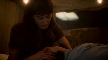 Movie still from “Snowpiercer” (2020), created by Graeme Manson – A woman is looking down at a man's arm; Close Up shot, High angle