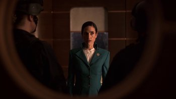 Movie still from “Snowpiercer” (2020), created by Graeme Manson – A woman in a green suit standing in front of a mirror; Medium shot, Over the shoulder angle