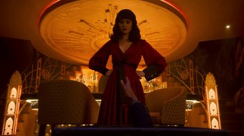 Movie still from “Snowpiercer” (2020), created by Graeme Manson – A woman in a red and black dress standing in front of a man; Medium shot, Over the shoulder angle