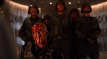 Movie still from “Snowpiercer” (2020), created by Graeme Manson – A group of men in military uniforms with blood all over their faces; Medium shot, Low angle