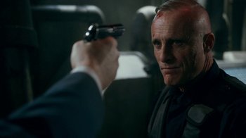 Movie still from “Snowpiercer” (2020), created by Graeme Manson – A man holding a gun pointed at another man in a car; Close Up shot, Over the shoulder angle