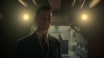 Movie still from “Snowpiercer” (2020), created by Graeme Manson – A man wearing a suit and tie standing in a room; Close Up shot, Low angle