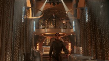 Movie still from “Snowpiercer” (2020), created by Graeme Manson – A woman standing in a room with a man standing on the top of the stairs; Extreme Wide shot, Low angle