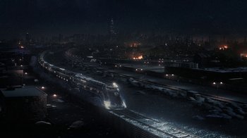 Movie still from “Snowpiercer” (2020), created by Graeme Manson – A train traveling down train tracks at night; Extreme Wide shot, High angle