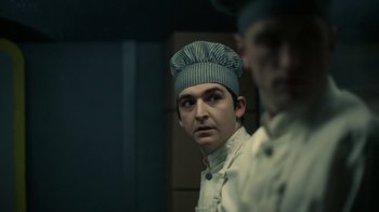 Movie still from “Snowpiercer” (2020), created by Graeme Manson – A man wearing a chef's hat in front of a mirror; Close Up shot, Low angle