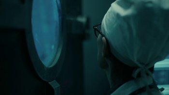 Movie still from “Snowpiercer” (2020), created by Graeme Manson – A person in a white hat looking in a mirror; Extreme Close Up shot, Over the shoulder angle