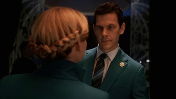 Movie still from “Snowpiercer” (2020), created by Graeme Manson – A man in a green suit looking at a woman in a blue suit; Close Up shot, Over the shoulder angle