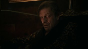 Movie still from “Snowpiercer” (2020), created by Graeme Manson – A man in a black shirt is sitting down; Close Up shot, Over the shoulder angle