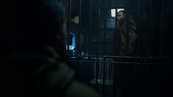 Movie still from “Snowpiercer” (2020), created by Graeme Manson – A man standing in front of a window in a jail cell; Medium shot, Over the shoulder angle