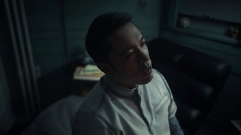 Movie still from “Snowpiercer” (2020), created by Graeme Manson – A man in a white shirt is sitting in a dark room; Close Up shot, High angle