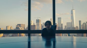 Movie still from “Mr. Robot” (2015), created by Sam Esmail – A man sitting at a table in front of a window; Medium shot, High angle