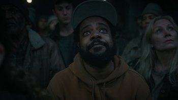 Movie still from “Snowpiercer” (2020), created by Graeme Manson – A man with a beard wearing a hat and looking up; Close Up shot, Over the shoulder angle