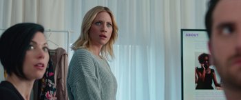 Movie still from “Someone Great” (2019), directed by Jennifer Kaytin Robinson – A woman standing in front of a window with curtains in the background; Medium shot, Low angle