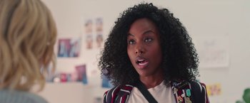 Movie still from “Someone Great” (2019), directed by Jennifer Kaytin Robinson – A person with curly black hair; Close Up shot, Over the shoulder angle