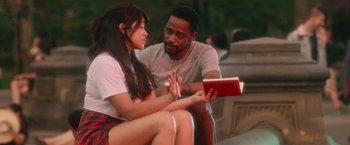 Movie still from “Someone Great” (2019), directed by Jennifer Kaytin Robinson – A man and a woman sitting next to each other holding a book; Medium shot, Over the shoulder angle