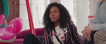 Movie still from “Someone Great” (2019), directed by Jennifer Kaytin Robinson – A woman sitting on top of a purple couch; Close Up shot, Over the shoulder angle