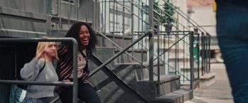 Movie still from “Someone Great” (2019), directed by Jennifer Kaytin Robinson – A woman sitting on top of a set of stairs; Medium shot, Low angle