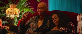 Movie still from “Someone Great” (2019), directed by Jennifer Kaytin Robinson – Two women sitting on a red couch next to each other; Close Up shot, High angle