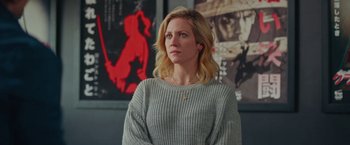 Movie still from “Someone Great” (2019), directed by Jennifer Kaytin Robinson – A woman standing in front of a wall with posters on the wall; Close Up shot, Over the shoulder angle