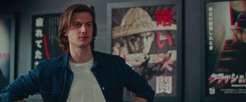 Movie still from “Someone Great” (2019), directed by Jennifer Kaytin Robinson – A man standing in front of an asian poster; Close Up shot, Low angle