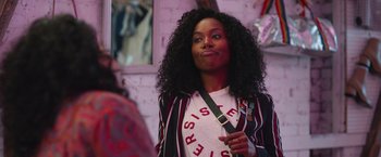 Movie still from “Someone Great” (2019), directed by Jennifer Kaytin Robinson – A woman with curly black hair is posing for a picture; Close Up shot, Over the shoulder angle