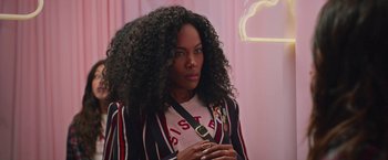 Movie still from “Someone Great” (2019), directed by Jennifer Kaytin Robinson – A black woman with long curly hair wearing a striped jacket; Close Up shot, Over the shoulder angle