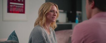 Movie still from “Someone Great” (2019), directed by Jennifer Kaytin Robinson – A woman with blonde hair sitting on a pink couch; Close Up shot, Over the shoulder angle