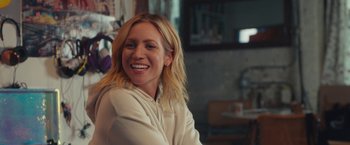 Movie still from “Someone Great” (2019), directed by Jennifer Kaytin Robinson – A woman smiling for the camera while sitting in a chair; Close Up shot, Over the shoulder angle