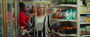 Movie still from “Someone Great” (2019), directed by Jennifer Kaytin Robinson – A group of people standing in front of shelves of food; Medium shot, Over the shoulder angle