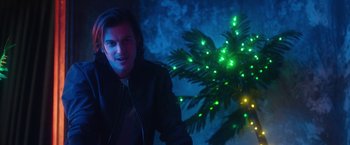 Movie still from “Someone Great” (2019), directed by Jennifer Kaytin Robinson – A man in a black leather jacket standing in front of a christmas tree; Medium shot, Low angle
