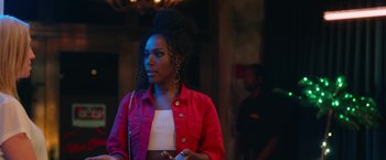 Movie still from “Someone Great” (2019), directed by Jennifer Kaytin Robinson – A woman in a red jacket standing in front of a wall; Medium shot, Over the shoulder angle