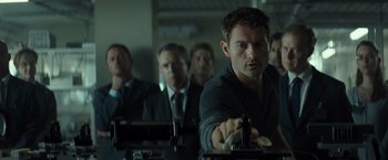 Movie still from “Spectral” (2016), directed by Nic Mathieu – A group of men in suits and ties in a room; Close Up shot, Low angle