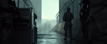 Movie still from “Spectral” (2016), directed by Nic Mathieu – A group of people walking down a street; Wide shot, Low angle