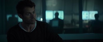Movie still from “Spectral” (2016), directed by Nic Mathieu – A man sitting in front of computer monitors; Close Up shot, Over the shoulder angle