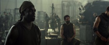 Movie still from “Spectral” (2016), directed by Nic Mathieu – Two men are sitting in a room in a factory; Medium shot, Over the shoulder angle