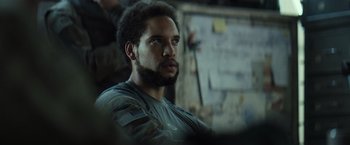 Movie still from “Spectral” (2016), directed by Nic Mathieu – A person with a beard looking to his left; Close Up shot, Over the shoulder angle