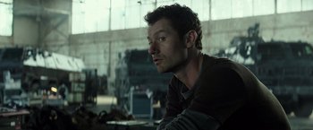 Movie still from “Spectral” (2016), directed by Nic Mathieu – A person sitting in front of a window; Close Up shot, Over the shoulder angle