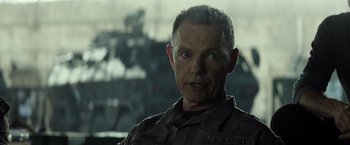 Movie still from “Spectral” (2016), directed by Nic Mathieu – A person wearing a military uniform; Close Up shot, Over the shoulder angle