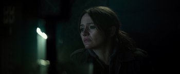 Movie still from “Spectral” (2016), directed by Nic Mathieu – A woman is looking into the distance in the dark; Close Up shot, Over the shoulder angle