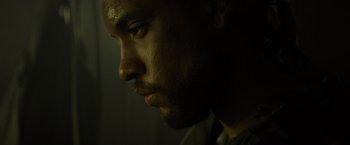 Movie still from “Spectral” (2016), directed by Nic Mathieu – A man's face in the dark; Close Up shot, Low angle