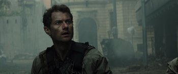 Movie still from “Spectral” (2016), directed by Nic Mathieu – A person with a gun in his hand; Close Up shot, Low angle