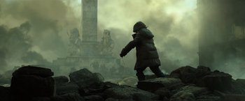 Movie still from “Spectral” (2016), directed by Nic Mathieu – A man in a hooded jacket walking on rocks; Wide shot, Low angle