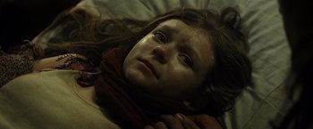 Movie still from “Spectral” (2016), directed by Nic Mathieu – A girl laying on a bed with her head resting on a pillow; Close Up shot, High angle